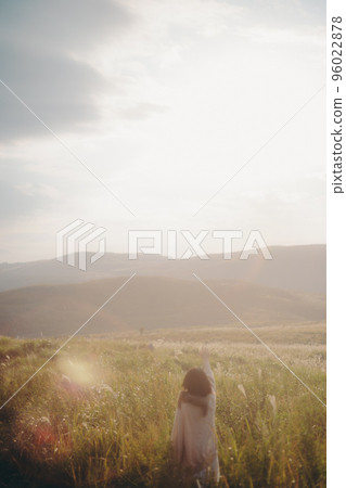 一個女人在日落時在大自然中聽音樂的照片 96022878