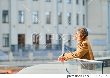 Pensive young woman at observation deck in a windy day 96023384
