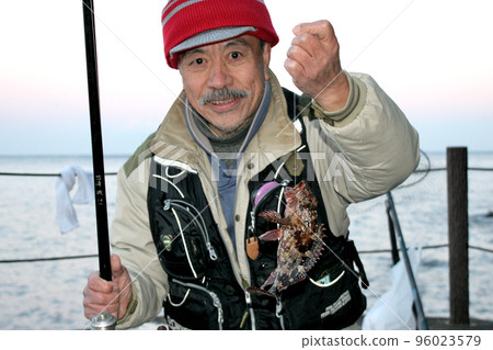 一位似乎很高興釣到岩魚的高級男性垂釣者 一位似乎很高興釣到岩魚的高級男性垂釣者 96023579