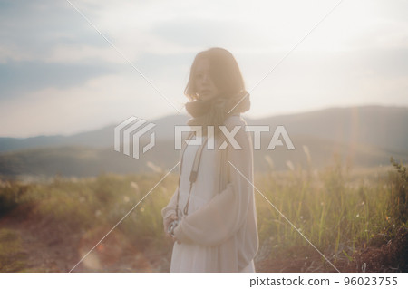 日落時在大自然中拿著相機的女人的照片 96023755