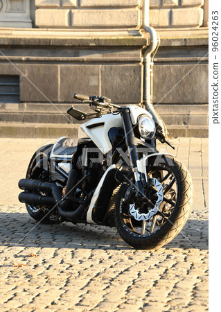 Vertical shot of a white chopper motorcycle parked under the sunlight 96024263