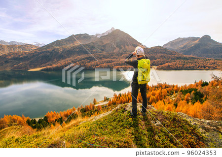 Man observes autumn landscape at a mountain lake 96024353