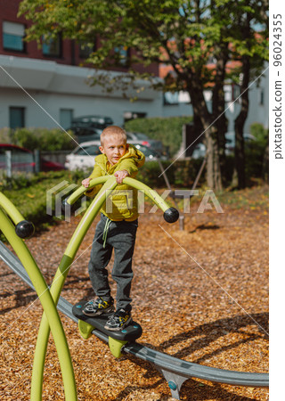 Funny cute happy baby playing on the playground. The emotion of happiness, fun, joy. Smile of a child. boy playing on the playground 96024355