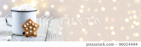 banner of a white cup of winter hot drink with marshmallows and gingerbread star on a white wooden background with bokeh. 96024494