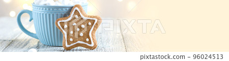 banner of a blue cup of winter hot drink with marshmallows and gingerbread star on a white wooden background with bokeh. 96024513