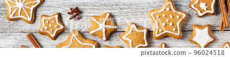 Border of Christmas gingerbreads in the shape of a star with patterns of glaze and spices on a white wooden background. Border of Christmas gingerbreads in the shape of a star with patterns of glaze and spices on a white wooden background. 96024518