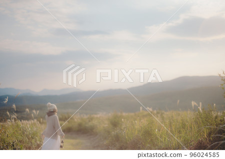 Photo of a woman standing in nature at sunset Photo of a woman standing in nature at sunset 96024585