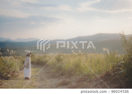 Photo of a woman standing in nature at sunset Photo of a woman standing in nature at sunset 96024586