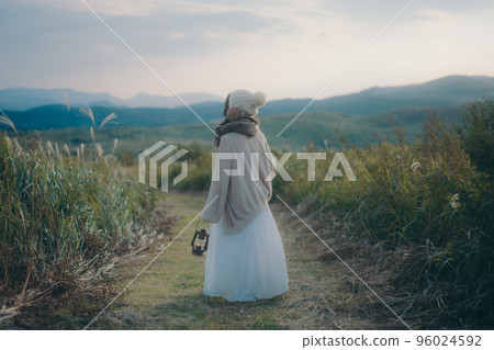 日落時站在大自然中的女人的照片 96024592