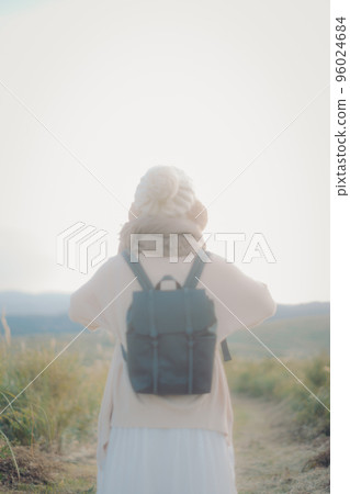 Photo of a woman standing in nature at sunset Photo of a woman standing in nature at sunset 96024684