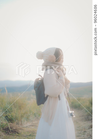 Photo of a woman standing in nature at sunset Photo of a woman standing in nature at sunset 96024686