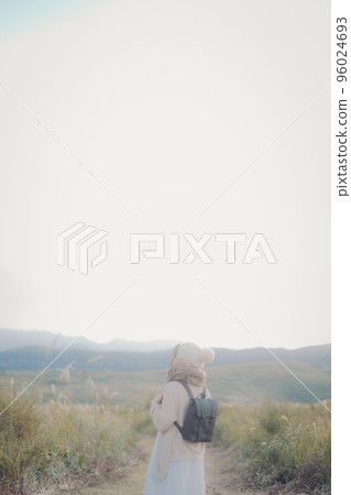 Photo of a woman standing in nature at sunset Photo of a woman standing in nature at sunset 96024693