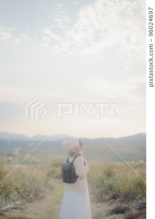 日落時站在大自然中的女人的照片 96024697