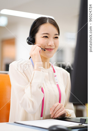 Young female operator working in a call center 96024784