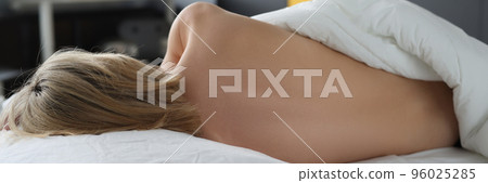 Young woman sleeping naked on silk bed clothes 96025285