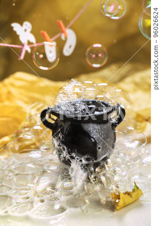 black cauldron filled with soapy foam, bubbles and washed ghosts on a rope. creative background for halloween black cauldron filled with soapy foam, bubbles and washed ghosts on a rope. creative background for halloween 96026624