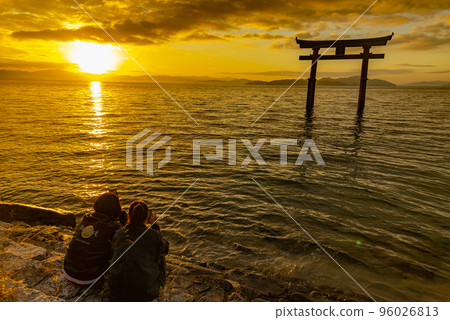 Shirahige shrine torii and lover standing in the morning sun and Lake Biwa Shirahige shrine torii and lover standing in the morning sun and Lake Biwa 96026813