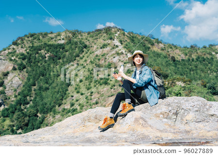 Woman taking a break from climbing 96027889