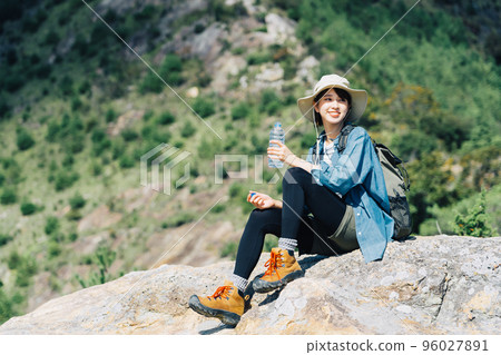 Woman drinking water on the mountain Woman drinking water on the mountain 96027891