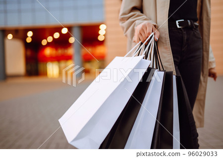 Young woman with shopping bags near mall. Spring Style. Consumerism, purchases, shopping, lifestyle. 96029033
