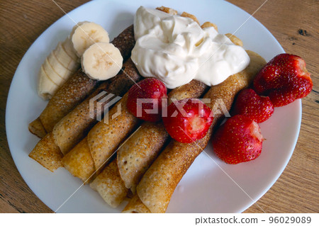 Delicious light breakfast. Pancakes with sour cream and fruit. 96029089