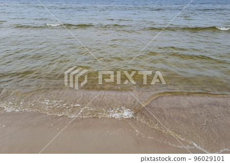 View of the blue waves that roll on the sandy shore. 96029101