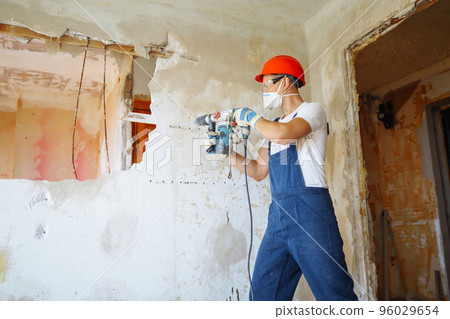 Repairer in boilersuit holding tools. Apartment repair and renovation concept. Building. Repairer in boilersuit holding tools. Apartment repair and renovation concept. Building. 96029654