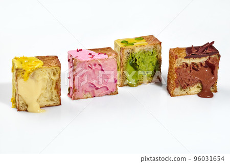 Cubed croissant halves with fillings of vanilla and berry custard, pistachio and chocolate cream Cubed croissant halves with fillings of vanilla and berry custard, pistachio and chocolate cream 96031654