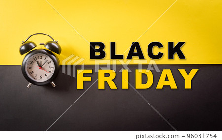 Top view of black alarm clock and the text on yellow and black background. Shopping concept boxing day and Black Friday composition. 96031754