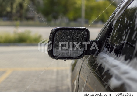 Washing mirrors in a car with active foam. Car wash. 96032533