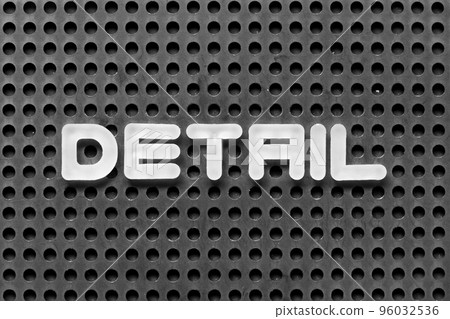 White alphabet letter in word detail on black pegboard background 96032536