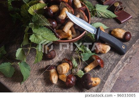 Pile of Imleria Badia or Boletus badius mushrooms commonly known as the bay bolete with knife on vintage wooden background.. 96033005