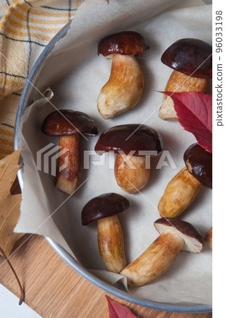 Vintage baking sheet with Imleria Badia or Boletus badius mushrooms commonly known as the bay bolete on wooden cutting board.. Vintage baking sheet with Imleria Badia or Boletus badius mushrooms commonly known as the bay bolete on wooden cutting board.. 96033198