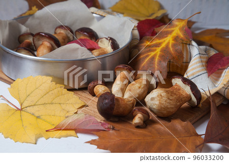 Several Imleria Badia or Boletus badius mushrooms commonly known as the bay bolete, vintage baking sheet with mushrooms on wooden cutting board.. Several Imleria Badia or Boletus badius mushrooms commonly known as the bay bolete, vintage baking sheet with mushrooms on wooden cutting board.. 96033200