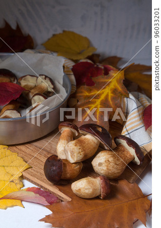 Several Imleria Badia or Boletus badius mushrooms commonly known as the bay bolete, vintage baking sheet with mushrooms on wooden cutting board.. Several Imleria Badia or Boletus badius mushrooms commonly known as the bay bolete, vintage baking sheet with mushrooms on wooden cutting board.. 96033201