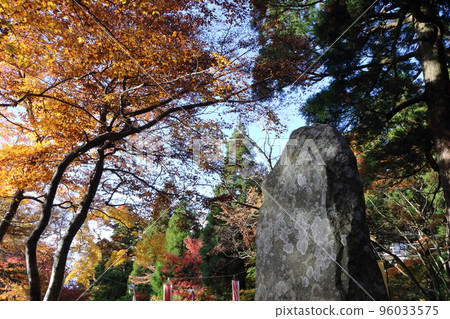 Autumn leaves and a stone monument under the blue sky Autumn leaves and a stone monument under the blue sky 96033575
