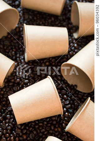 Mock up disposable coffee cups lying on coffee beans. Some empty paper coffee cups Mock up disposable coffee cups lying on coffee beans. Some empty paper coffee cups 96034392