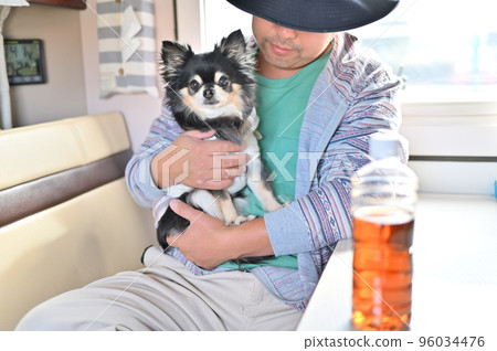 一個男人在露營車里和吉娃娃一起放鬆 96034476