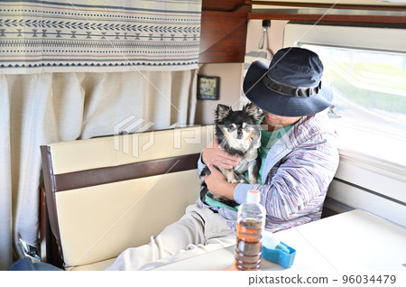 A man relaxing with a chihuahua in a camper A man relaxing with a chihuahua in a camper 96034479