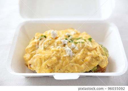 Avocado and scrambled eggs toast with delivery package in white background 96035092