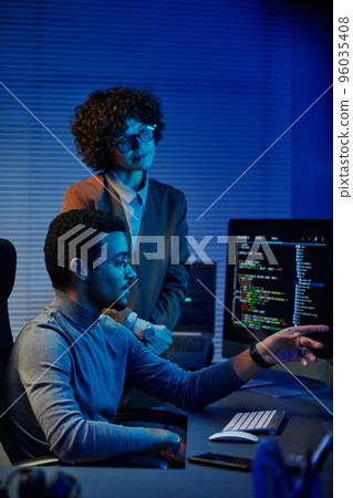 Confident IT engineer or software developer pointing at computer screen 96035408