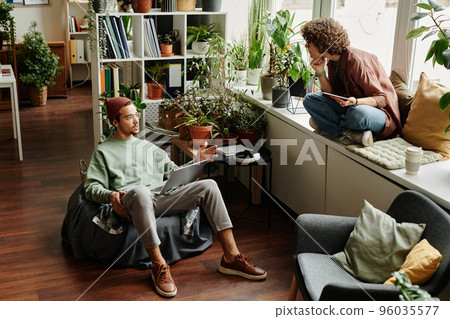 Two young designers or IT engineers having discussion Two young designers or IT engineers having discussion 96035577