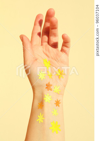 Female hand with painted flowers on beige background Female hand with painted flowers on beige background 96037104