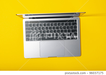 Open laptop on yellow background, top view Open laptop on yellow background, top view 96037175