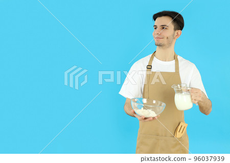 Concept of cooking, young man in apron on blue background Concept of cooking, young man in apron on blue background 96037939