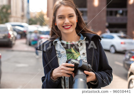 Attractive tourist woman photographer with camera, outdoor in city street. Attractive tourist woman photographer with camera, outdoor in city street. 96038441