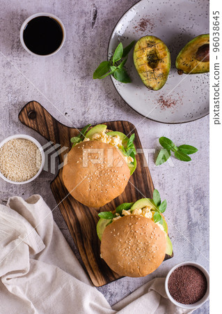 Hamburger with avocado, scrambled eggs and basil on a board. Healthy food. Top and vertical view 96038645