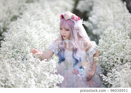 Portrait of Asian young woman with lolita fashion dress in white flower garden background 96038951