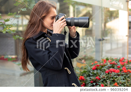 Happy woman on vacation photographing with camera on the city street 96039204