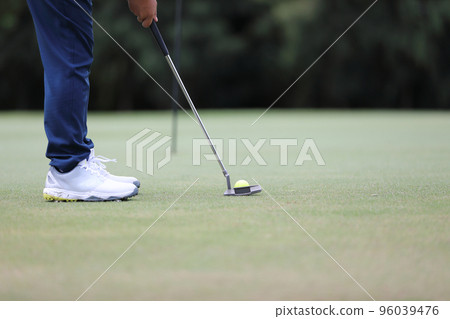 Golf ball on green grass ready to be struck on grass background Golf ball on green grass ready to be struck on grass background 96039476